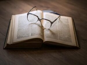 Pair of glasses on top of an open book.